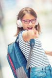Écolière avec le sac, sac à dos Portrait de fille de l'adolescence heureuse moderne d'école avec les écouteurs et le comprimé de photo libre de droits Écolière avec le sac, sac à dos Portrait de fille de l'adolescence heureuse moderne d'école avec les écouteurs et le comprimé de photo libre de droits