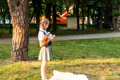 Écolière dans l'uniforme mangeant une pomme en parc image libre de droits Écolière dans l'uniforme mangeant une pomme en parc image libre de droits