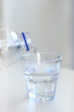 Écoulements d'eau propres de bouteille au verre photos libres de droits Écoulements d'eau propres de bouteille au verre photos libres de droits
