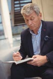 Écriture attentive d'homme d'affaires dans l'organisateur image stock Écriture attentive d'homme d'affaires dans l'organisateur image stock