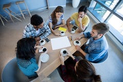 Équipe créative d'affaires ayant se réunir au-dessus du café dans le lieu de réunion images stock Équipe créative d'affaires ayant se réunir au-dessus du café dans le lieu de réunion images stock