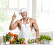 Équipez le bodybuilder dans le blanche blanc de toque et faites cuire le tablier protecteur photographie stock libre de droits Équipez le bodybuilder dans le blanche blanc de toque et faites cuire le tablier protecteur photographie stock libre de droits
