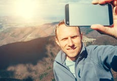 Équipez prennent la photo d'individu avec le smartphone sur le dessus de la montagne Photographie stock libre de droits Équipez prennent la photo d'individu avec le smartphone sur le dessus de la montagne Photographie stock libre de droits