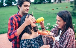 Équipez tenir le hot-dog dans le barbecue avec des amis photo libre de droits Équipez tenir le hot-dog dans le barbecue avec des amis photo libre de droits