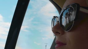 Équitation de femme au siège arrière de la voiture, à la réflexion des paumes et au bord de mer dans des lunettes de soleil banque de vidéos Équitation de femme au siège arrière de la voiture, à la réflexion des paumes et au bord de mer dans des lunettes de soleil banque de vidéos