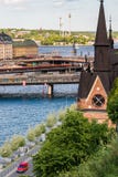 ÉSTOCOLMO, SUÉCIA - 14 DE JULHO DE 2017: Vista sobre Mariahissen, cidade velha e Djurgarden de Södermalm em Éstocolmo, Suécia fotos de stock ÉSTOCOLMO, SUÉCIA - 14 DE JULHO DE 2017: Vista sobre Mariahissen, cidade velha e Djurgarden de Södermalm em Éstocolmo, Suécia fotos de stock