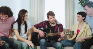 Étnicos multi de los amigos felices y atractivos disfrutan del tiempo junto en una sala de estar grande ellos que juegan en una g almacen de metraje de vídeo Étnicos multi de los amigos felices y atractivos disfrutan del tiempo junto en una sala de estar grande ellos que juegan en una g almacen de metraje de vídeo