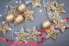 Étoiles et boules d'or de jouets de Noël sur un fond gris photographie stock libre de droits Étoiles et boules d'or de jouets de Noël sur un fond gris photographie stock libre de droits