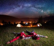Étoiles lumineuses admiratives de couples affectueux et mensonge sur l'herbe Photographie stock libre de droits Étoiles lumineuses admiratives de couples affectueux et mensonge sur l'herbe Photographie stock libre de droits