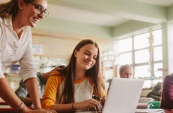 Étudiant de aide de haut maître d'école dans la salle de classe image stock Étudiant de aide de haut maître d'école dans la salle de classe image stock