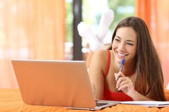 Étudiant heureux apprenant sur le lit image libre de droits Étudiant heureux apprenant sur le lit image libre de droits