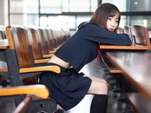 Étudiante asiatique dans l'uniforme scolaire apprenant dans la salle de classe image libre de droits Étudiante asiatique dans l'uniforme scolaire apprenant dans la salle de classe image libre de droits
