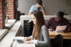 Étudiante étudiant pour des examens utilisant l'ordinateur portable photo libre de droits Étudiante étudiant pour des examens utilisant l'ordinateur portable photo libre de droits