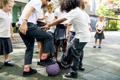 Étudiants de jardin d'enfants jouant le football ensemble photographie stock Étudiants de jardin d'enfants jouant le football ensemble photographie stock