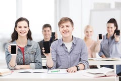 Étudiants montrant les écrans vides noirs de smartphone photo stock Étudiants montrant les écrans vides noirs de smartphone photo stock