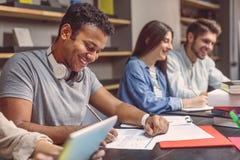 Étudiants universitaires s'asseyant ensemble et étudiant Photo stock