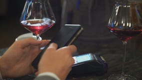 Άτομο που κάνει την πληρωμή μέσω της τεχνολογίας NFC στο κινητό τηλέφωνο στον καφέ απόθεμα βίντεο Άτομο που κάνει την πληρωμή μέσω της τεχνολογίας NFC στο κινητό τηλέφωνο στον καφέ απόθεμα βίντεο
