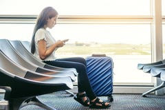 Ασιατικές ταξιδιωτικές γυναίκες που ψάχνουν την πτήση στο smartphone στην τελική έννοια ταξιδιού αερολιμένων στοκ εικόνες Ασιατικές ταξιδιωτικές γυναίκες που ψάχνουν την πτήση στο smartphone στην τελική έννοια ταξιδιού αερολιμένων στοκ εικόνες