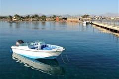 Βάρκα με μια μηχανή στην αποβάθρα στο ήρεμο νερό της Ερυθράς Θάλασσας στοκ φωτογραφίες με δικαίωμα ελεύθερης χρήσης Βάρκα με μια μηχανή στην αποβάθρα στο ήρεμο νερό της Ερυθράς Θάλασσας στοκ φωτογραφίες με δικαίωμα ελεύθερης χρήσης