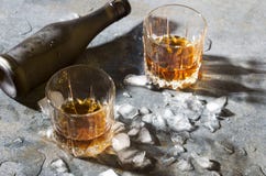 Γυαλιά με τους κύβους πάγου κονιάκ και λειωμένων μετάλλων, μπουκάλι στο μετρητή φραγμών στοκ εικόνες με δικαίωμα ελεύθερης χρήσης Γυαλιά με τους κύβους πάγου κονιάκ και λειωμένων μετάλλων, μπουκάλι στο μετρητή φραγμών στοκ εικόνες με δικαίωμα ελεύθερης χρήσης