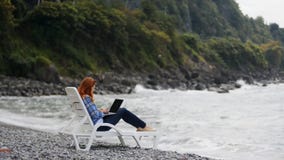 Γυναίκα που εργάζεται στο lap-top κοντά στη θάλασσα φιλμ μικρού μήκους Γυναίκα που εργάζεται στο lap-top κοντά στη θάλασσα φιλμ μικρού μήκους