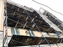 Εργασία επισκευής για την πρόσοψη του κτηρίου με τη βοήθεια των ξύλινων υλικών σκαλωσιάς, δομές, αποκατάσταση του παλαιού σπιτιού στοκ φωτογραφία με δικαίωμα ελεύθερης χρήσης Εργασία επισκευής για την πρόσοψη του κτηρίου με τη βοήθεια των ξύλινων υλικών σκαλωσιάς, δομές, αποκατάσταση του παλαιού σπιτιού στοκ φωτογραφία με δικαίωμα ελεύθερης χρήσης