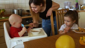 Η νοικοκυρά στην κουζίνα ταΐζει το γιο και την κόρη της για το γεύμα το λουλούδι ημέρας δίνει το γιο μητέρων mum φιλμ μικρού μήκους Η νοικοκυρά στην κουζίνα ταΐζει το γιο και την κόρη της για το γεύμα το λουλούδι ημέρας δίνει το γιο μητέρων mum φιλμ μικρού μήκους