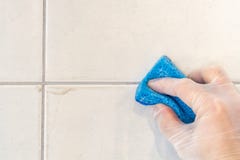 Η ένωση κεραμιδιών καθαρίζεται του ρύπου και της φόρμας με ένα σφουγγάρι στοκ εικόνες Η ένωση κεραμιδιών καθαρίζεται του ρύπου και της φόρμας με ένα σφουγγάρι στοκ εικόνες