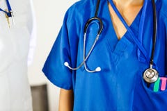 Θηλυκός γιατρός σε μια μπλε τήβεννο με ένα στηθοσκόπιο στοκ εικόνα με δικαίωμα ελεύθερης χρήσης Θηλυκός γιατρός σε μια μπλε τήβεννο με ένα στηθοσκόπιο στοκ εικόνα με δικαίωμα ελεύθερης χρήσης