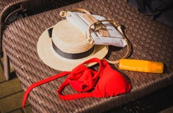Καπέλο αχύρου, τσάντα, κόκκινα μαγιό και sunscreen σε ένα υπόβαθρο αχύρου στοκ φωτογραφία Καπέλο αχύρου, τσάντα, κόκκινα μαγιό και sunscreen σε ένα υπόβαθρο αχύρου στοκ φωτογραφία