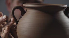 Κλείστε επάνω των χεριών δημιουργεί ήπια την κανάτα από τον άργιλο Ο αγγειοπλάστης δημιουργεί το προϊόν φιλμ μικρού μήκους Κλείστε επάνω των χεριών δημιουργεί ήπια την κανάτα από τον άργιλο Ο αγγειοπλάστης δημιουργεί το προϊόν φιλμ μικρού μήκους
