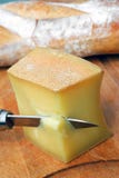 Κομμάτι του τυριού Abondance με ένα μαχαίρι και ένα ψωμί στοκ φωτογραφία Κομμάτι του τυριού Abondance με ένα μαχαίρι και ένα ψωμί στοκ φωτογραφία