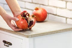 Κόκκινο juicy ώριμο ρόδι στα θηλυκά χέρια βλάβη στοκ φωτογραφία με δικαίωμα ελεύθερης χρήσης Κόκκινο juicy ώριμο ρόδι στα θηλυκά χέρια βλάβη στοκ φωτογραφία με δικαίωμα ελεύθερης χρήσης