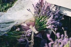 Μια ανθοδέσμη lavender που δένεται με μια δικτυωτή κορδέλλα βρίσκεται στο επιτραπέζιο πόδι στοκ εικόνες Μια ανθοδέσμη lavender που δένεται με μια δικτυωτή κορδέλλα βρίσκεται στο επιτραπέζιο πόδι στοκ εικόνες