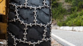 Μπροστινός φορτωτής για την αφαίρεση χιονιού με τις αλυσίδες χιονιού μετάλλων στις ρόδες Αφαίρεση χιονιού στα βουνά στοκ φωτογραφία με δικαίωμα ελεύθερης χρήσης Μπροστινός φορτωτής για την αφαίρεση χιονιού με τις αλυσίδες χιονιού μετάλλων στις ρόδες Αφαίρεση χιονιού στα βουνά στοκ φωτογραφία με δικαίωμα ελεύθερης χρήσης