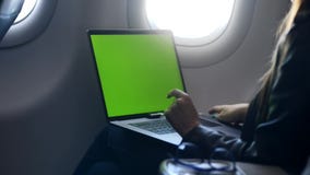 Νέα γυναίκα που χρησιμοποιεί το lap-top, που στέλνει το ηλεκτρονικό ταχυδρομείο στο αεροπλάνο φιλμ μικρού μήκους Νέα γυναίκα που χρησιμοποιεί το lap-top, που στέλνει το ηλεκτρονικό ταχυδρομείο στο αεροπλάνο φιλμ μικρού μήκους