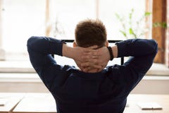 Οπισθοσκόπος συνεδρίαση επιχειρηματιών στην καρέκλα που βάζει τα χέρια πίσω από το κεφάλι στοκ φωτογραφία Οπισθοσκόπος συνεδρίαση επιχειρηματιών στην καρέκλα που βάζει τα χέρια πίσω από το κεφάλι στοκ φωτογραφία