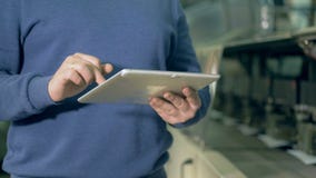 Ένα άτομο δακτυλογραφεί σε μια ταμπλέτα σε ένα γραφείο τυπωμένων υλών, κλείνει επάνω απόθεμα βίντεο Ένα άτομο δακτυλογραφεί σε μια ταμπλέτα σε ένα γραφείο τυπωμένων υλών, κλείνει επάνω απόθεμα βίντεο