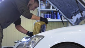 Ένας εργαζόμενος υπηρεσιών χύνει το συνθετικό πετρέλαιο σε ένα επιβατικό αυτοκίνητο μέσα σε ένα πρατήριο βενζίνης απόθεμα βίντεο Ένας εργαζόμενος υπηρεσιών χύνει το συνθετικό πετρέλαιο σε ένα επιβατικό αυτοκίνητο μέσα σε ένα πρατήριο βενζίνης απόθεμα βίντεο