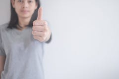 Όμορφη ασιατική γυναίκα που παρουσιάζει αντίχειρες σε ένα άσπρο υπόβαθρο με το διάστημα αντιγράφων στοκ εικόνες Όμορφη ασιατική γυναίκα που παρουσιάζει αντίχειρες σε ένα άσπρο υπόβαθρο με το διάστημα αντιγράφων στοκ εικόνες