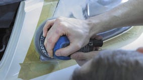 Στίλβωση προβολέων, επεξεργασία των φω'των αυτοκινήτων Ένας εργαζόμενος υπηρεσιών αυτοκινήτων γυαλίζει τον προβολέα ενός επιβατικ απόθεμα βίντεο Στίλβωση προβολέων, επεξεργασία των φω'των αυτοκινήτων Ένας εργαζόμενος υπηρεσιών αυτοκινήτων γυαλίζει τον προβολέα ενός επιβατικ απόθεμα βίντεο