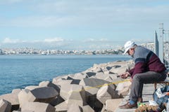 Στις 16 Δεκεμβρίου της Αθήνας, Ελλάδα 2018 ψάρια συλλήψεων ψαράδων από τον κυματοθραύστη στοκ φωτογραφία με δικαίωμα ελεύθερης χρήσης Στις 16 Δεκεμβρίου της Αθήνας, Ελλάδα 2018 ψάρια συλλήψεων ψαράδων από τον κυματοθραύστη στοκ φωτογραφία με δικαίωμα ελεύθερης χρήσης