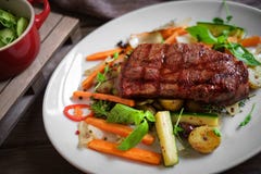 Ψημένη στη σχάρα Juicy μπριζόλα βόειου κρέατος Striploin με τα λαχανικά στο πιάτο στοκ φωτογραφίες Ψημένη στη σχάρα Juicy μπριζόλα βόειου κρέατος Striploin με τα λαχανικά στο πιάτο στοκ φωτογραφίες