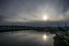Το ναυπηγείο στον ποταμό sates ως ήλιο κατεβαίνει αργά στον ορίζοντα στοκ εικόνα Το ναυπηγείο στον ποταμό sates ως ήλιο κατεβαίνει αργά στον ορίζοντα στοκ εικόνα