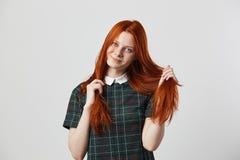 Το όμορφο redhead μακρυμάλλες κορίτσι σε ένα πράσινο ελεγμένο φόρεμα κρατά το χέρι της στις τρίχες της στο άσπρο υπόβαθρο στοκ εικόνες Το όμορφο redhead μακρυμάλλες κορίτσι σε ένα πράσινο ελεγμένο φόρεμα κρατά το χέρι της στις τρίχες της στο άσπρο υπόβαθρο στοκ εικόνες