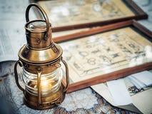 Το παλαιό μπρούτζινο φανάρι σκαφών στέκεται σε έναν χάρτη των θαλασσών κοντά στις εικόνες με την εικόνα των κόμβων θάλασσας στοκ εικόνα με δικαίωμα ελεύθερης χρήσης Το παλαιό μπρούτζινο φανάρι σκαφών στέκεται σε έναν χάρτη των θαλασσών κοντά στις εικόνες με την εικόνα των κόμβων θάλασσας στοκ εικόνα με δικαίωμα ελεύθερης χρήσης