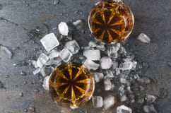Τοπ άποψη των γυαλιών με το κονιάκ και κομμάτια του πάγου στην γκρίζα επιφάνεια συμβαλλόμενο μέρος ποτών στοκ φωτογραφία με δικαίωμα ελεύθερης χρήσης Τοπ άποψη των γυαλιών με το κονιάκ και κομμάτια του πάγου στην γκρίζα επιφάνεια συμβαλλόμενο μέρος ποτών στοκ φωτογραφία με δικαίωμα ελεύθερης χρήσης