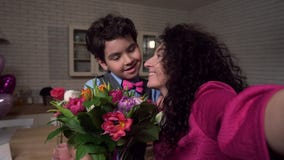 Χαρούμενο mom που παίρνει selfie με τα λουλούδια εκμετάλλευσης γιων απόθεμα βίντεο Χαρούμενο mom που παίρνει selfie με τα λουλούδια εκμετάλλευσης γιων απόθεμα βίντεο