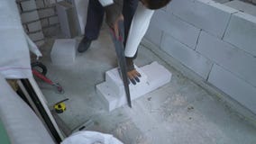 Υψηλός πυροβολισμός γωνίας του οικοδόμου που πριονίζει τον αερισμένο τσιμεντένιο ογκόλιθο μετά από να μετρήσει το απόθεμα βίντεο Υψηλός πυροβολισμός γωνίας του οικοδόμου που πριονίζει τον αερισμένο τσιμεντένιο ογκόλιθο μετά από να μετρήσει το απόθεμα βίντεο