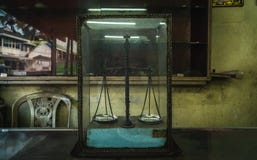 Παλαιά κλίμακα βάρους σε ένα γυαλί στοκ εικόνα με δικαίωμα ελεύθερης χρήσης Παλαιά κλίμακα βάρους σε ένα γυαλί στοκ εικόνα με δικαίωμα ελεύθερης χρήσης